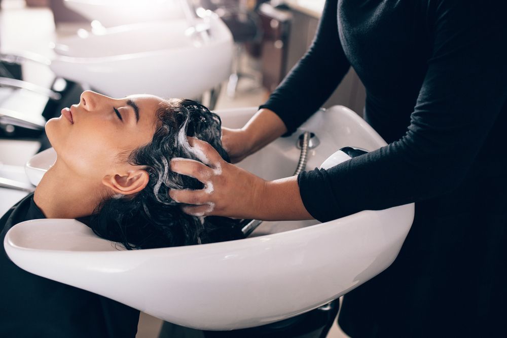 A woman is getting her hair washed at a salon.