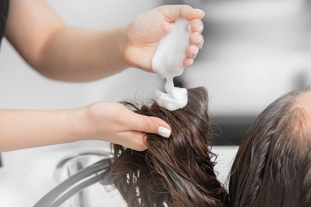 A woman is getting her hair washed at a salon.