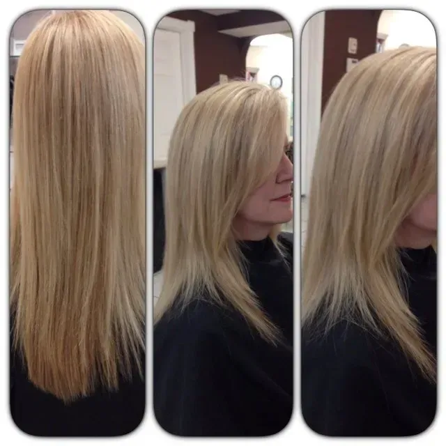 A woman with long blonde hair is wearing a black shirt