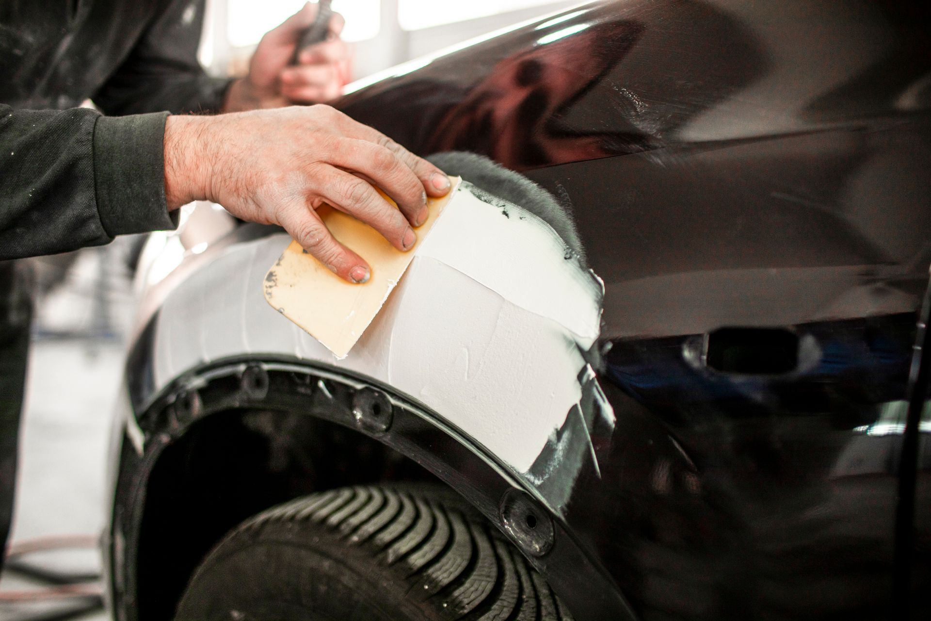 Repairing an accident-damaged car part using a car filler.