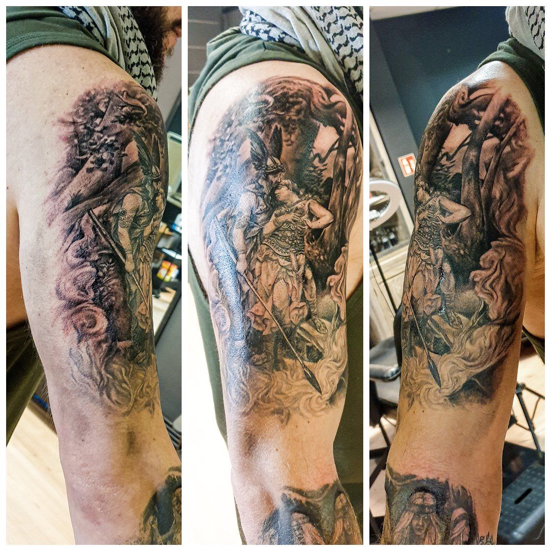 Een man heeft een tatoeage op zijn arm die op een schilderij lijkt.