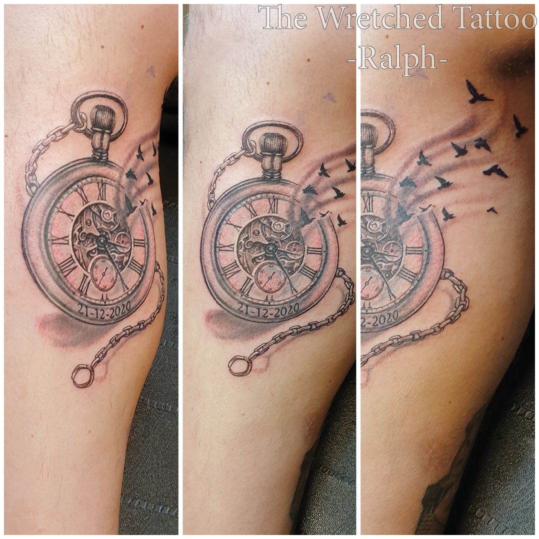 Een tatoeage van een zakhorloge met vogels eromheen vliegend