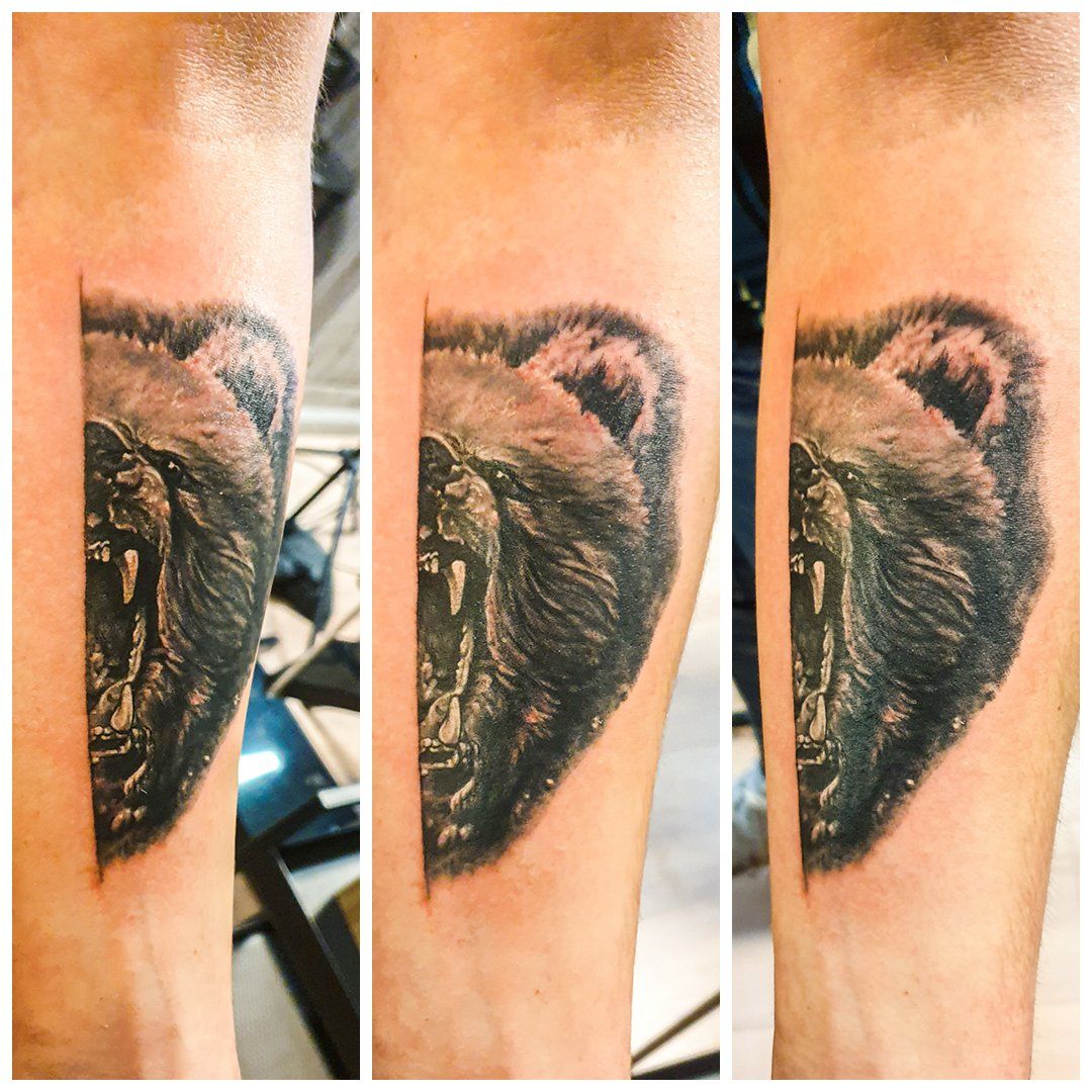 Een man heeft een tatoeage van een beer op zijn been