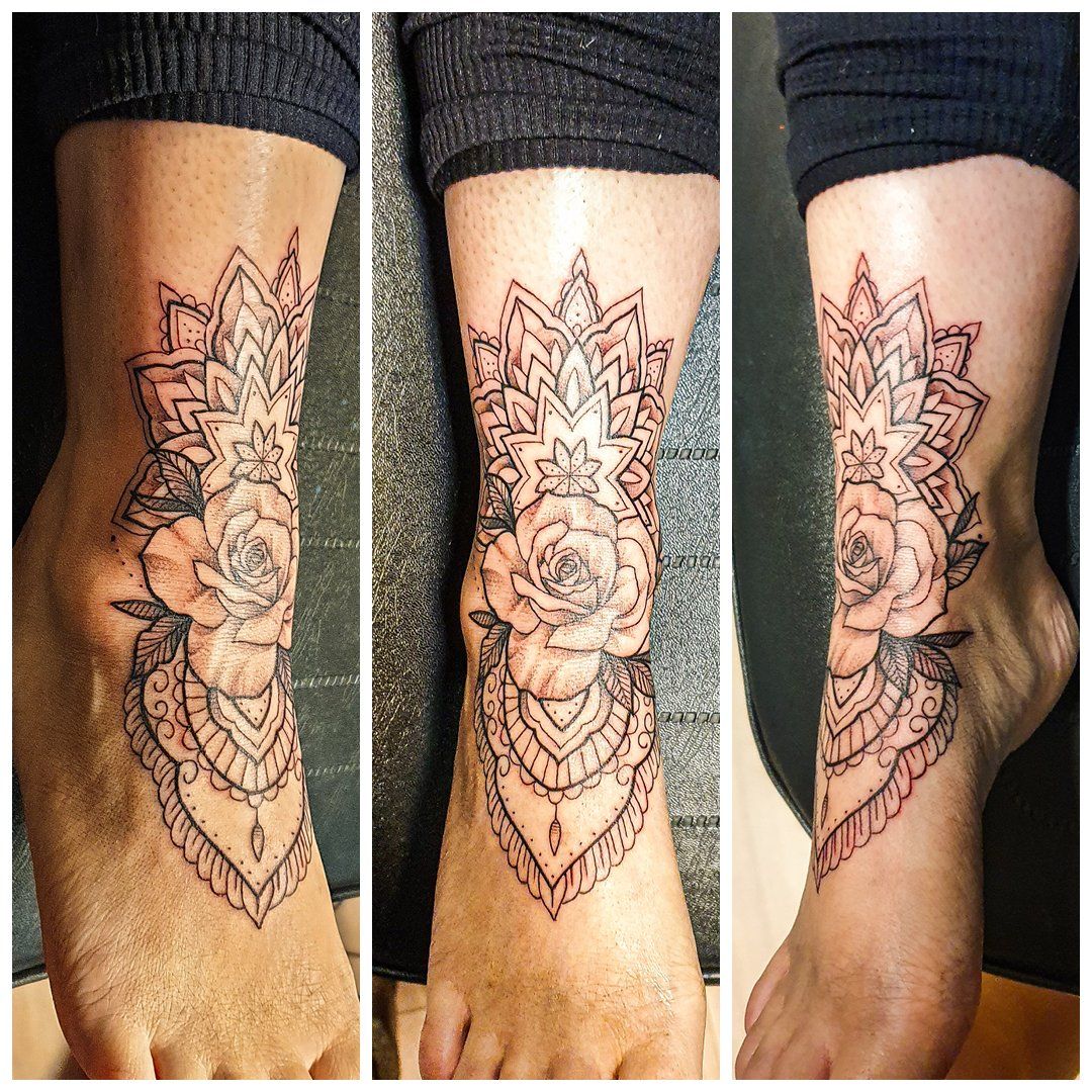 Een vrouw heeft een tatoeage op haar enkel die op een mandala lijkt.