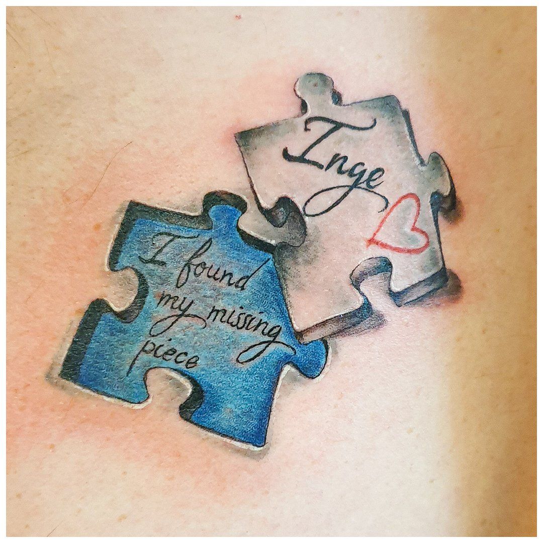 Een tatoeage van twee puzzelstukjes met de woorden "ik heb mijn ontbrekende stukje gevonden"