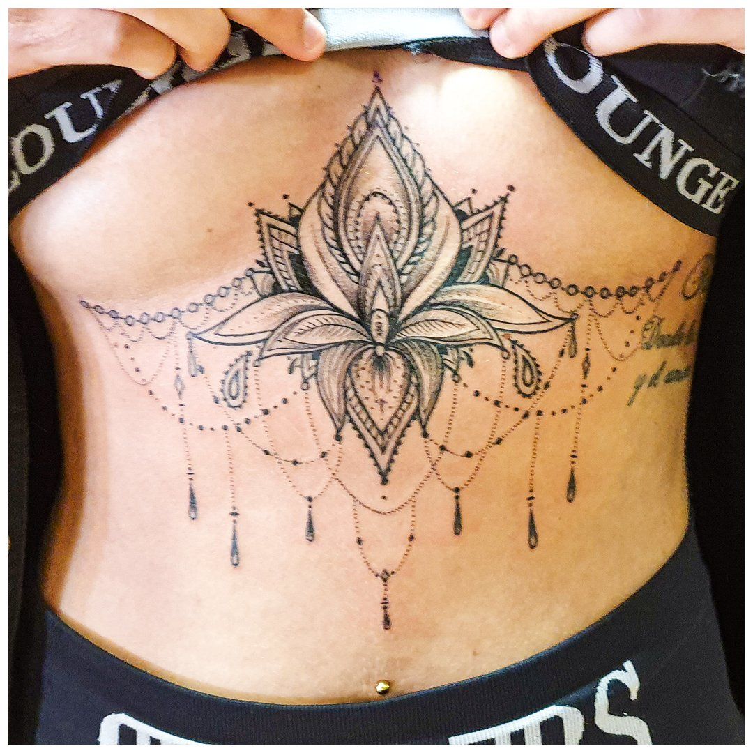 Een vrouw heeft een tatoeage van een lotusbloem op haar borst