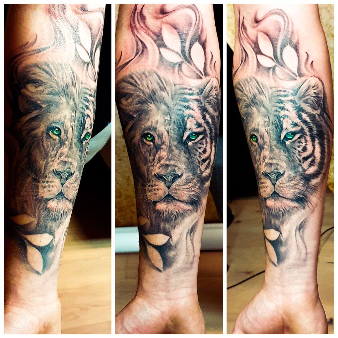 Een man heeft een tatoeage van een leeuw en een tijger op zijn onderarm
