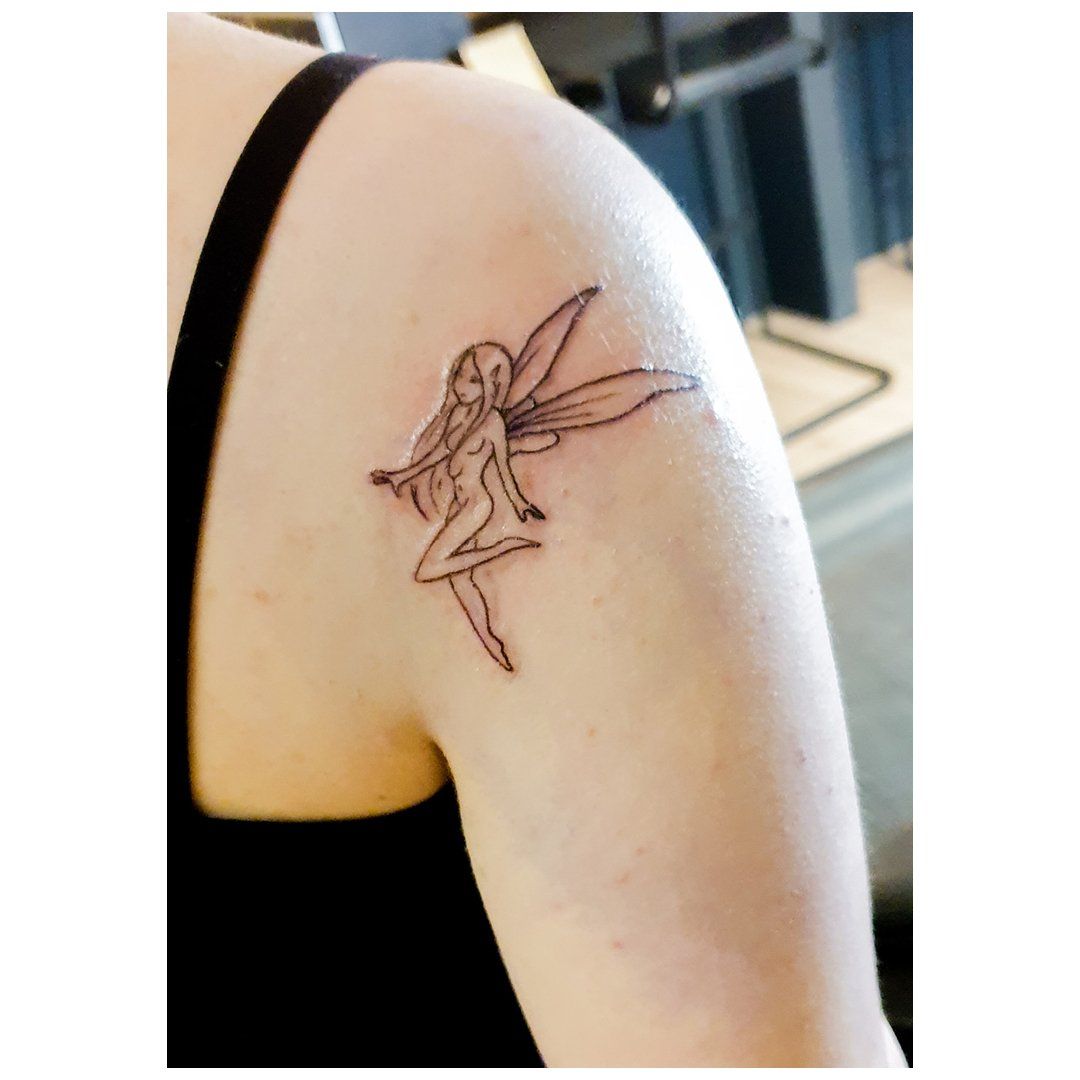 Een vrouw heeft een tatoeage van een fee op haar schouder