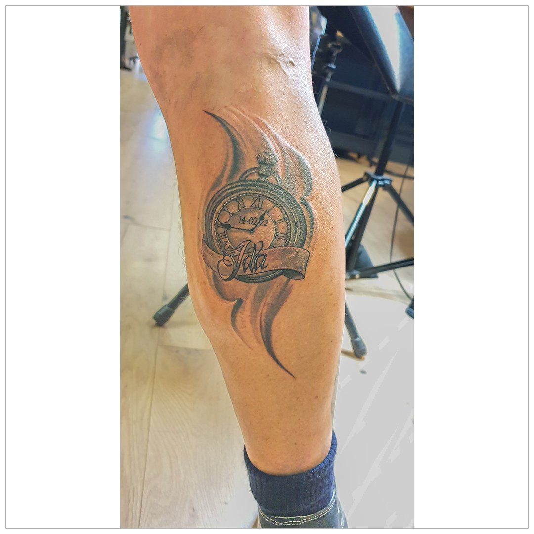 Een persoon heeft een tatoeage van een zakhorloge op zijn been.