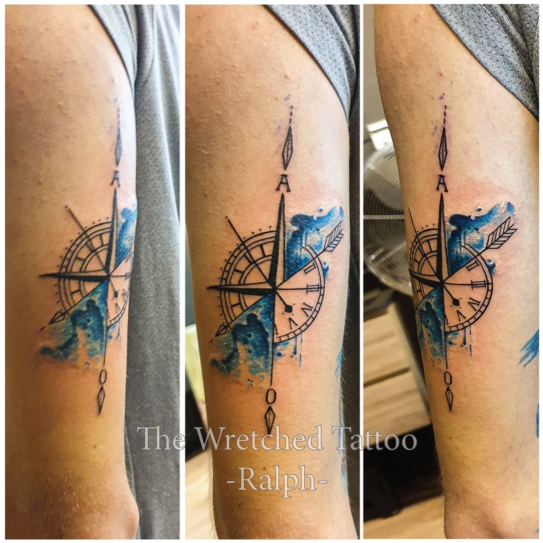 Een man heeft een tatoeage van een kompas op zijn arm