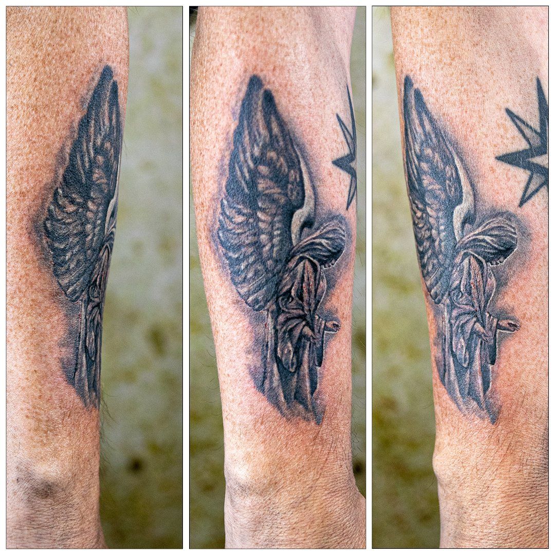 Een man heeft een tatoeage van een engel op zijn been.