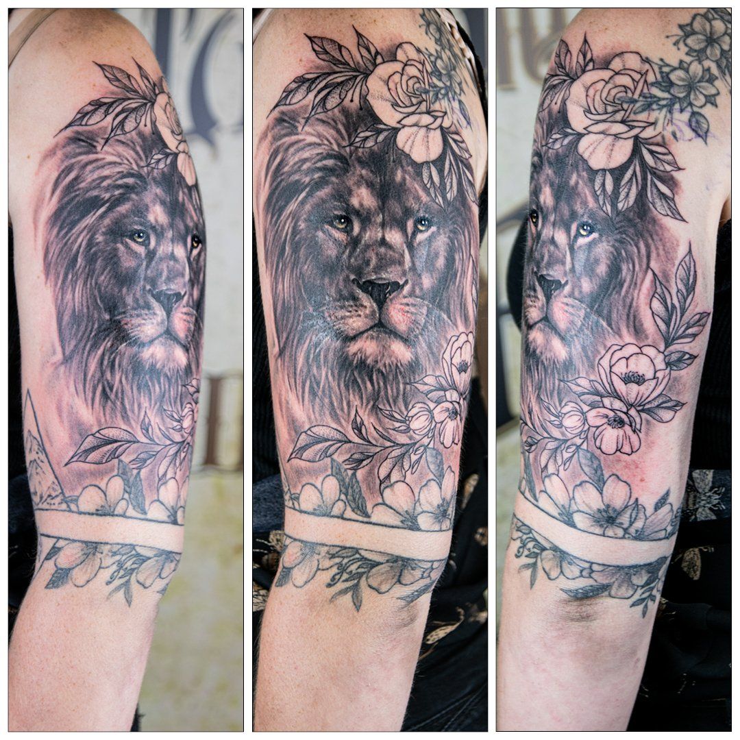 Een vrouw heeft een tatoeage van een leeuw en bloemen op haar arm.