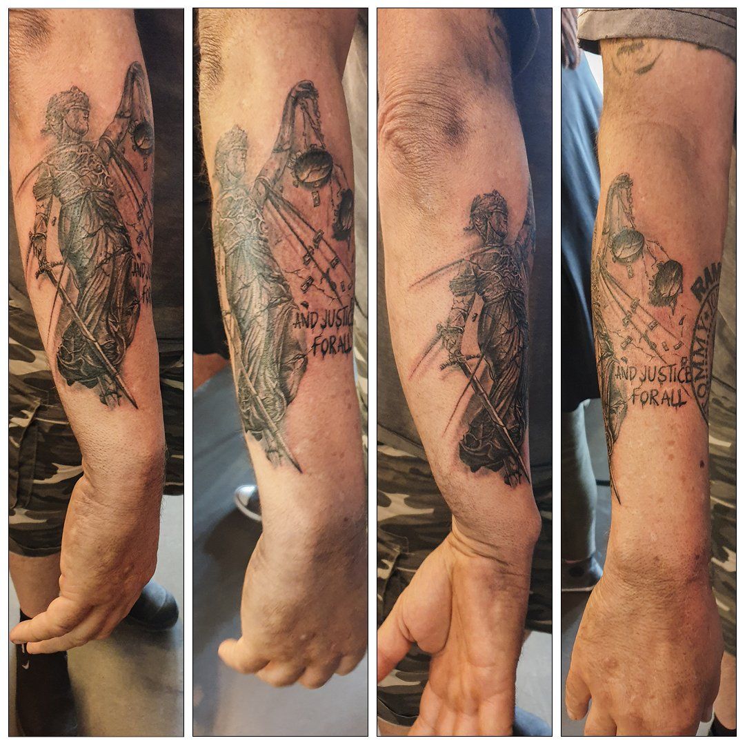 Een man heeft een tatoeage van gerechtigheid op zijn arm