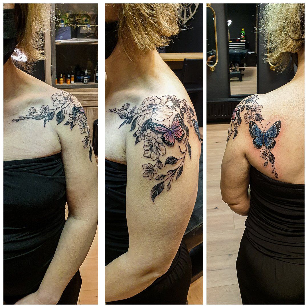 Een vrouw heeft een tatoeage van bloemen en vlinders op haar schouder.
