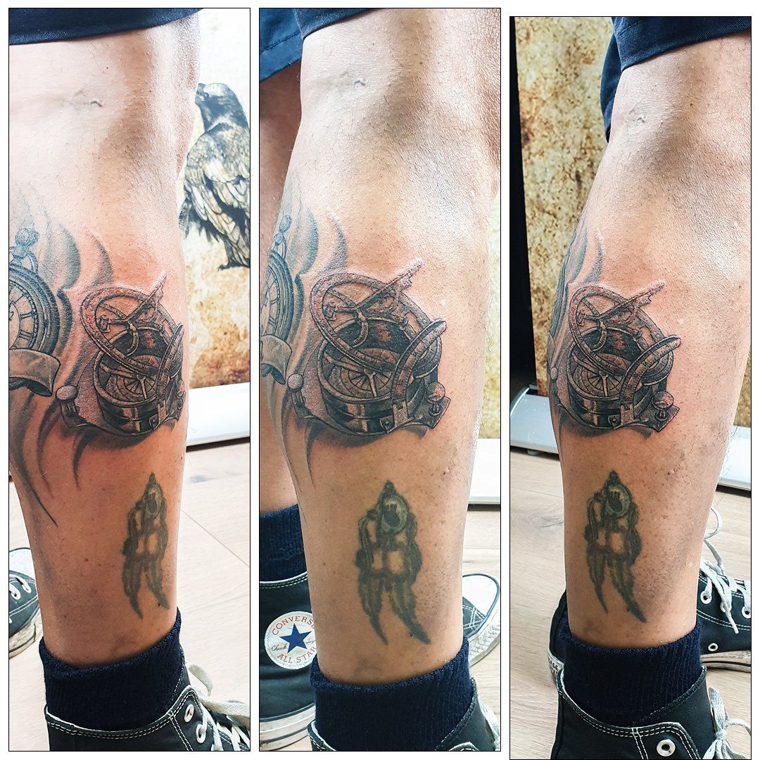 Een persoon heeft een tatoeage op zijn been met een klok erop