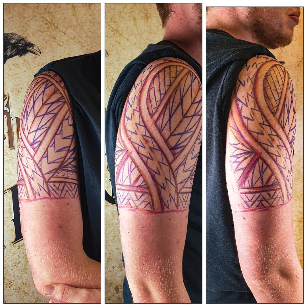 Een man heeft een tribale tatoeage op zijn arm