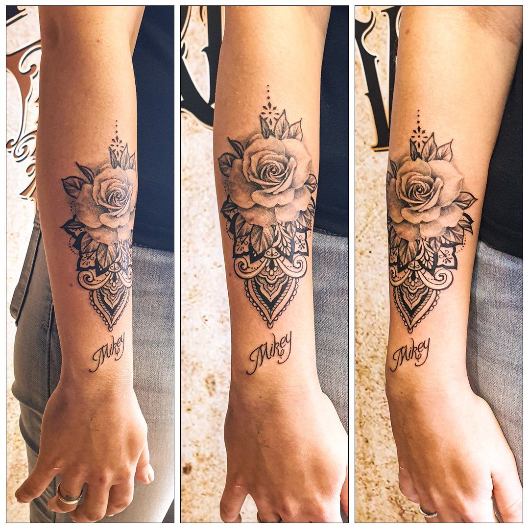 Een vrouw heeft een tatoeage van rozen op haar onderarm.