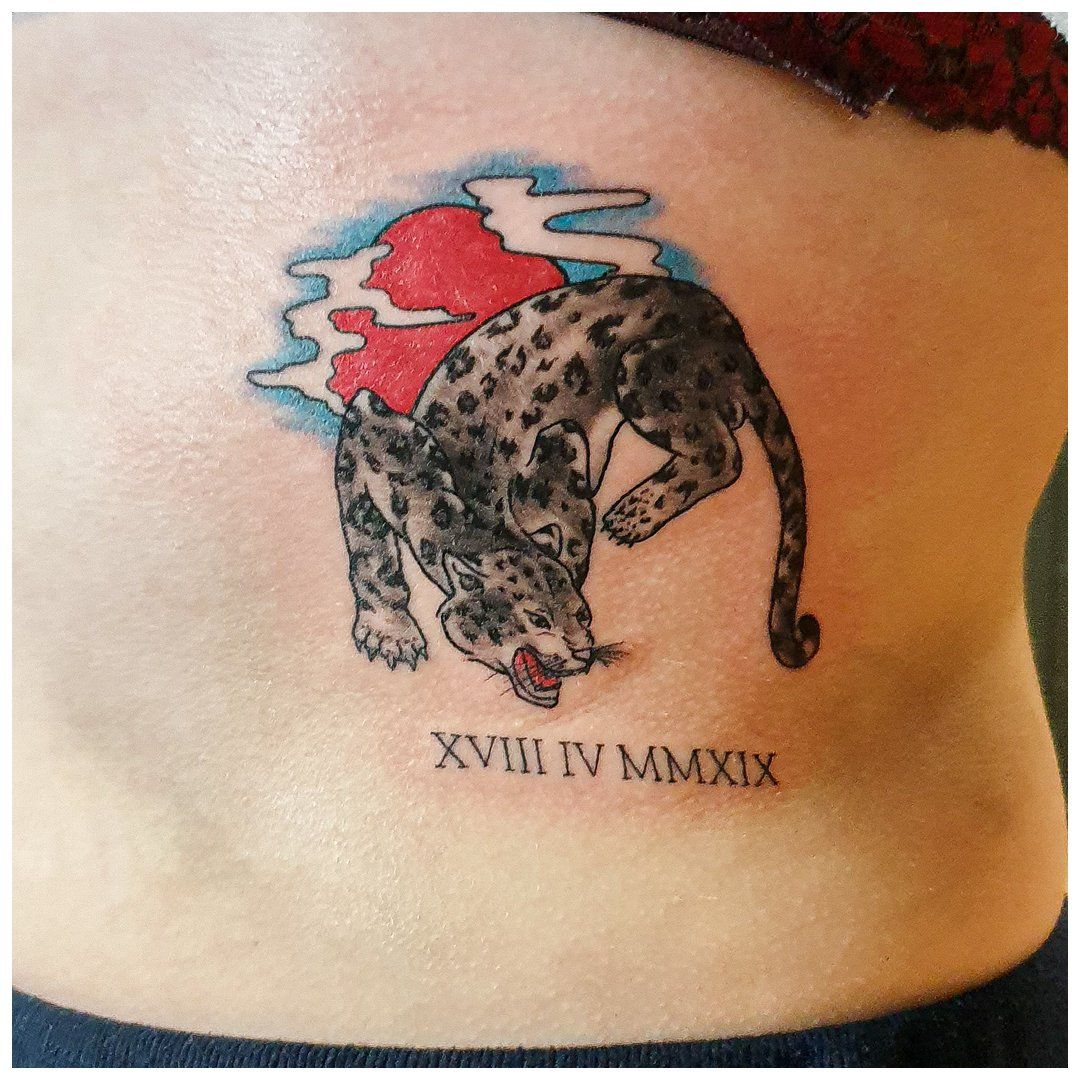 Een tatoeage van een luipaard en de datum xviii iv mmxx