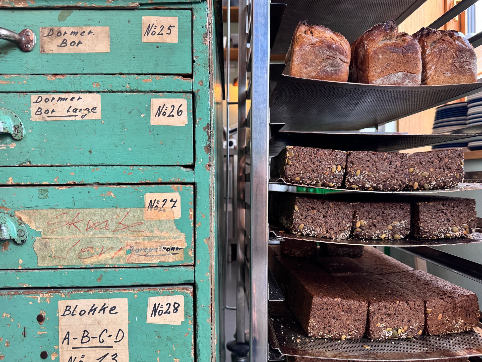 Three bags of coffee with red polka dots in a wooden tray, alongside a chocolate card.