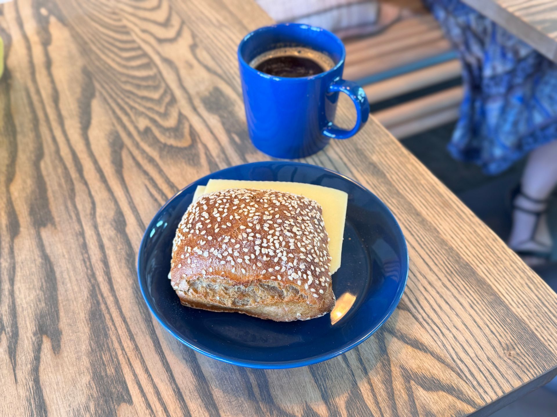 Coffee, glass carafe, and small glass on wooden tray, set on cobblestone.