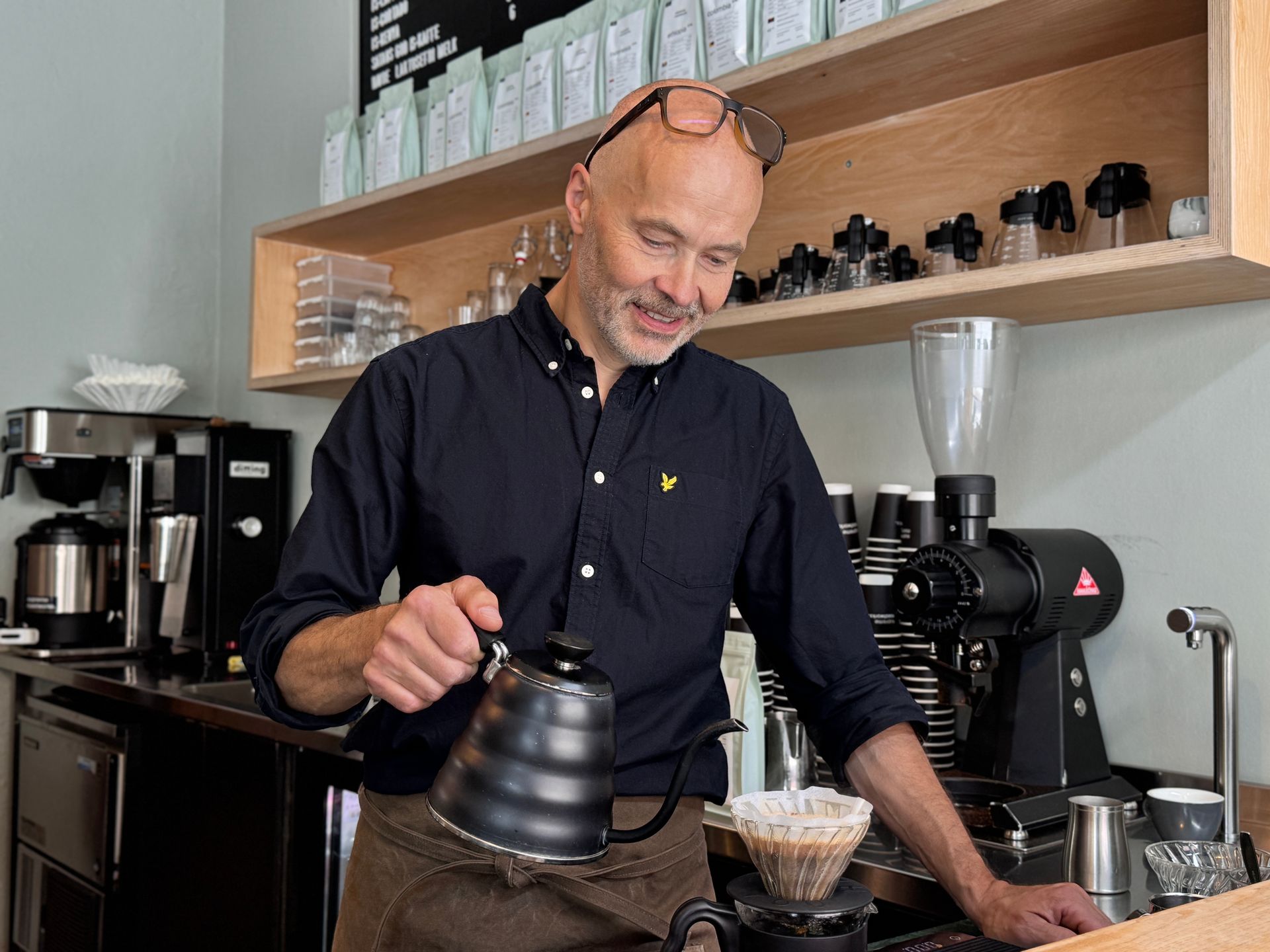 Barista pours water over coffee grounds in a cafe.