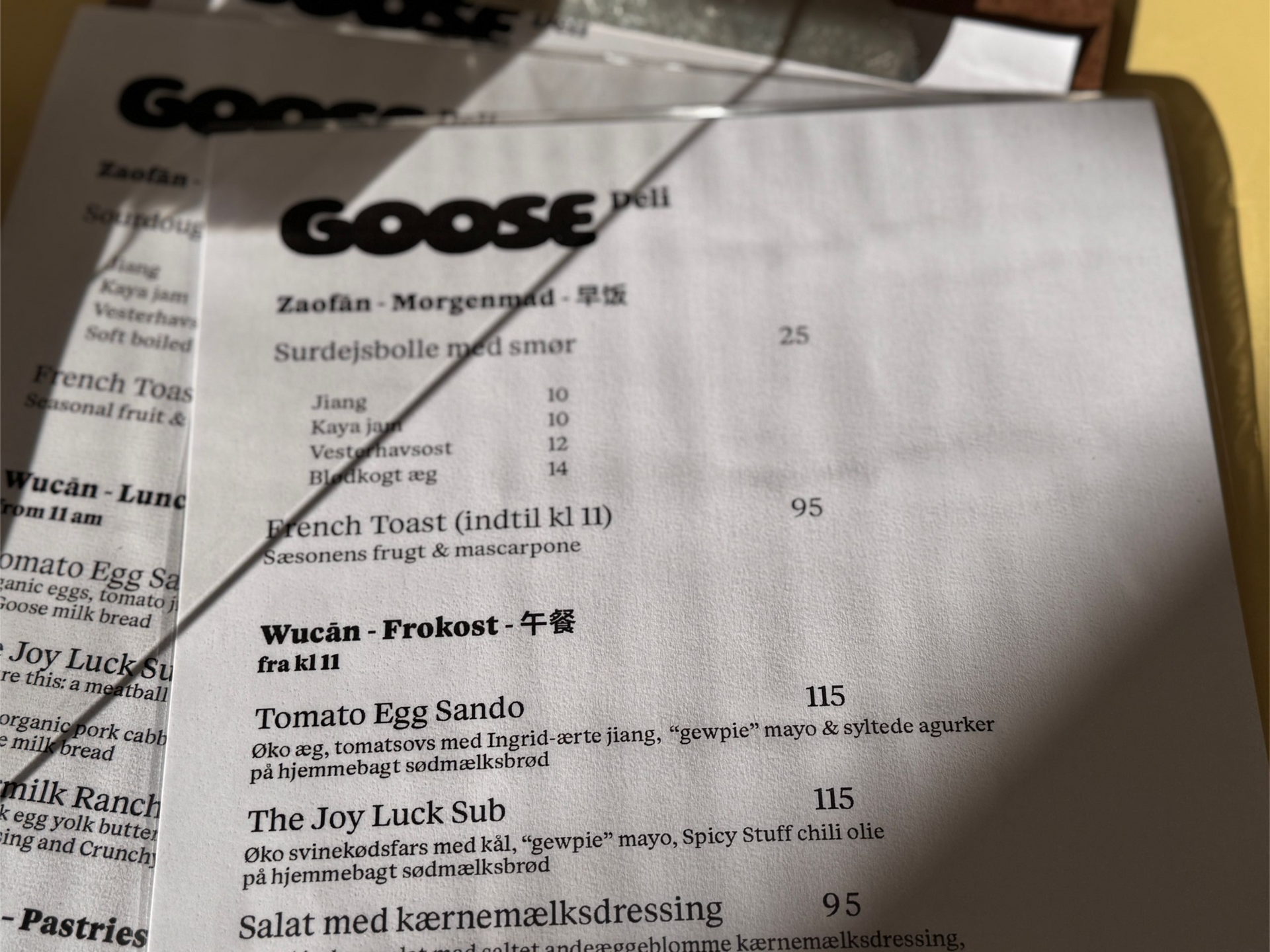 Three bags of coffee with red polka dots in a wooden tray, alongside a chocolate card.