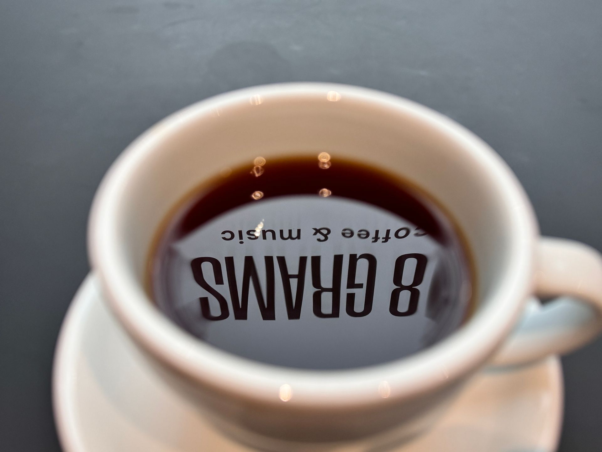 Three bags of coffee with red polka dots in a wooden tray, alongside a chocolate card.
