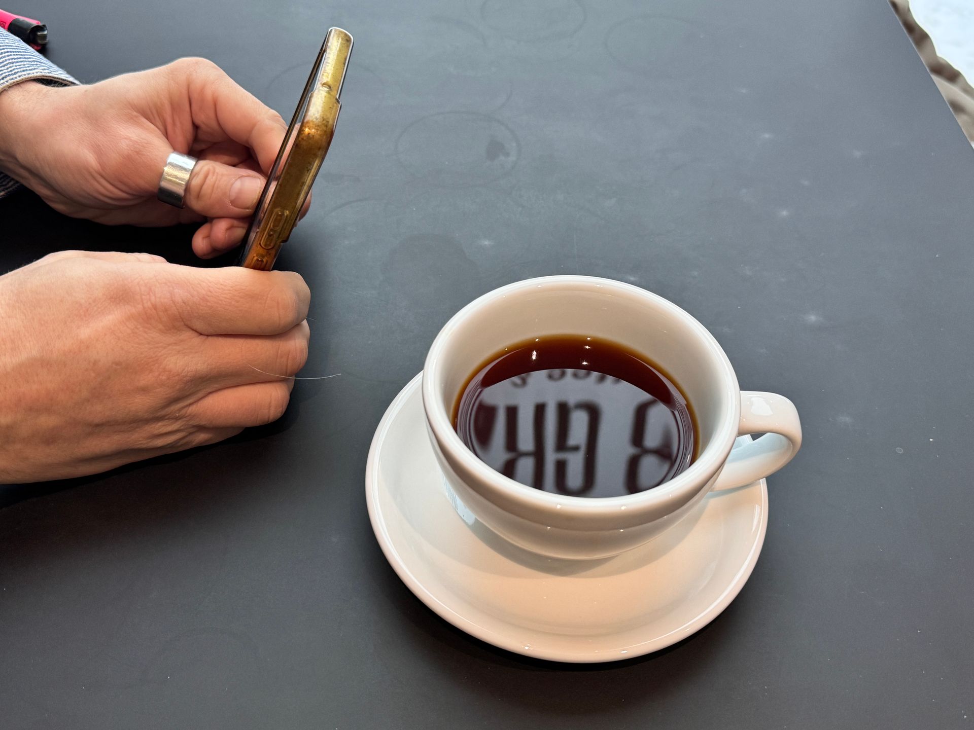 Coffee, glass carafe, and small glass on wooden tray, set on cobblestone.