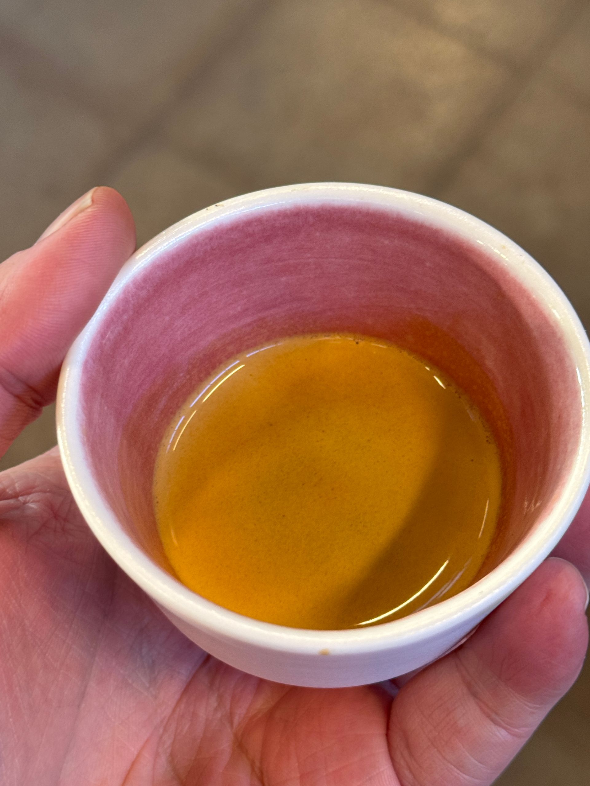 Black espresso maker and accessories in an open travel case on a wooden surface.