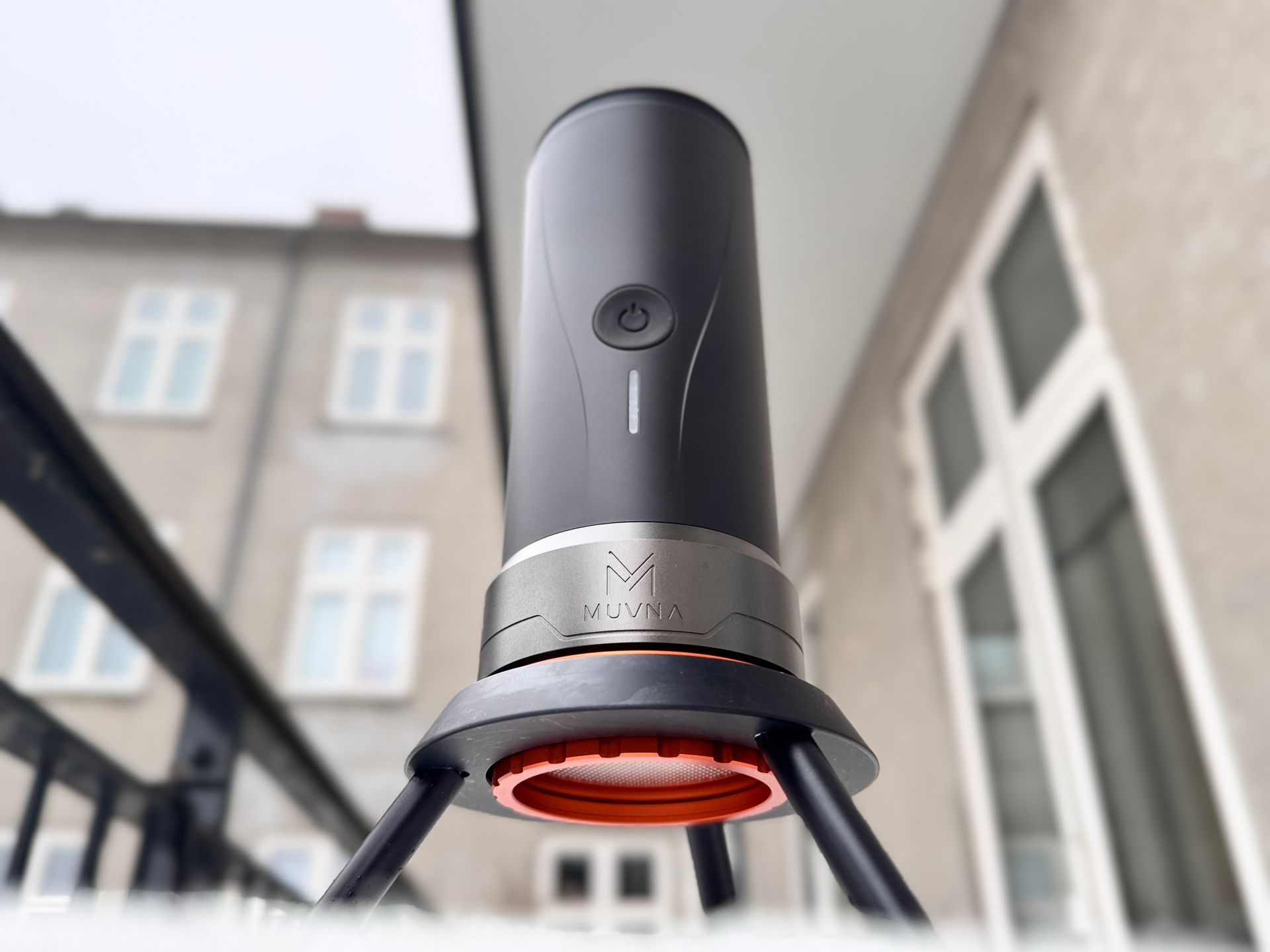 Black and orange portable espresso maker on snow.