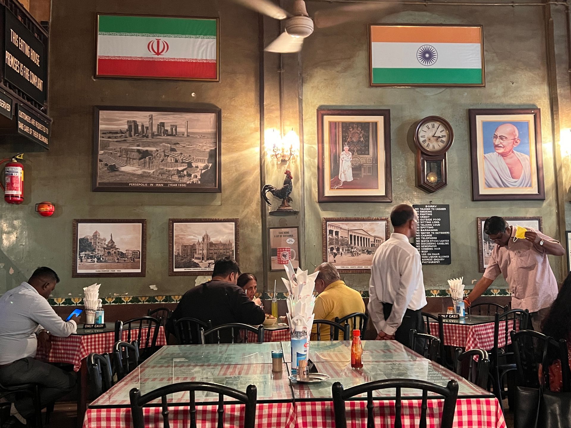 A restaurant with a sign on the wall that says exotic parsi and indian cuisine only cash.
