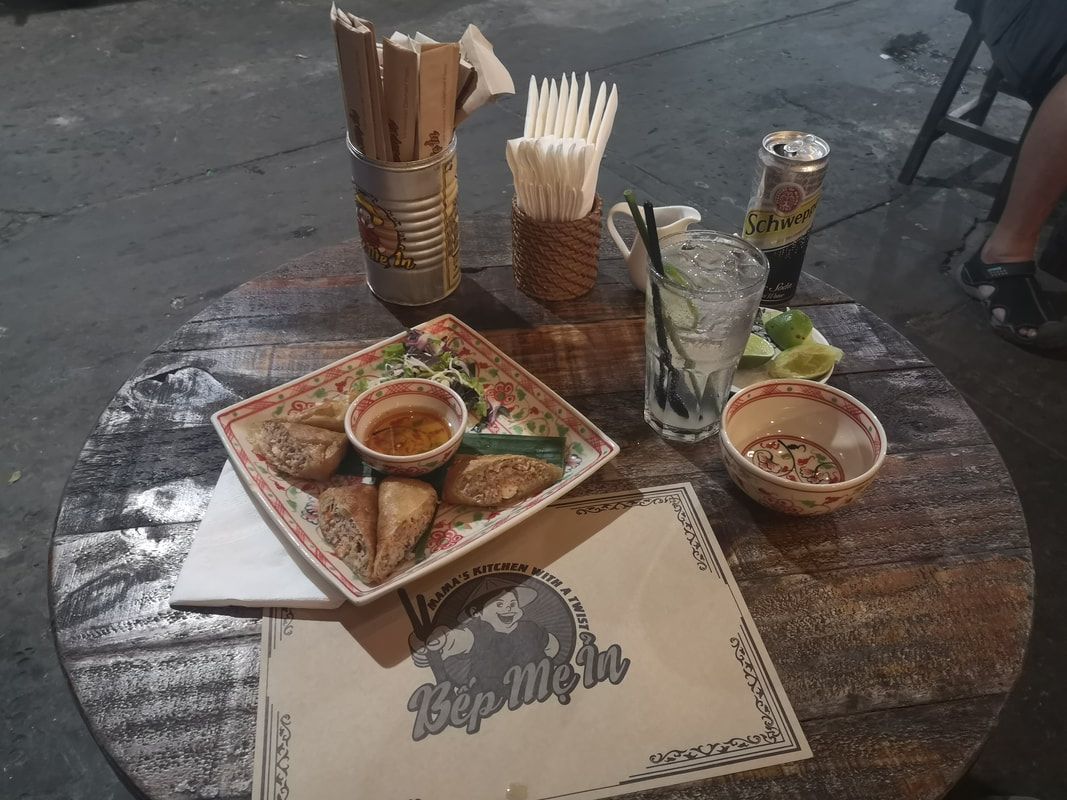 Table with food, drinks, and menus at an outdoor restaurant.