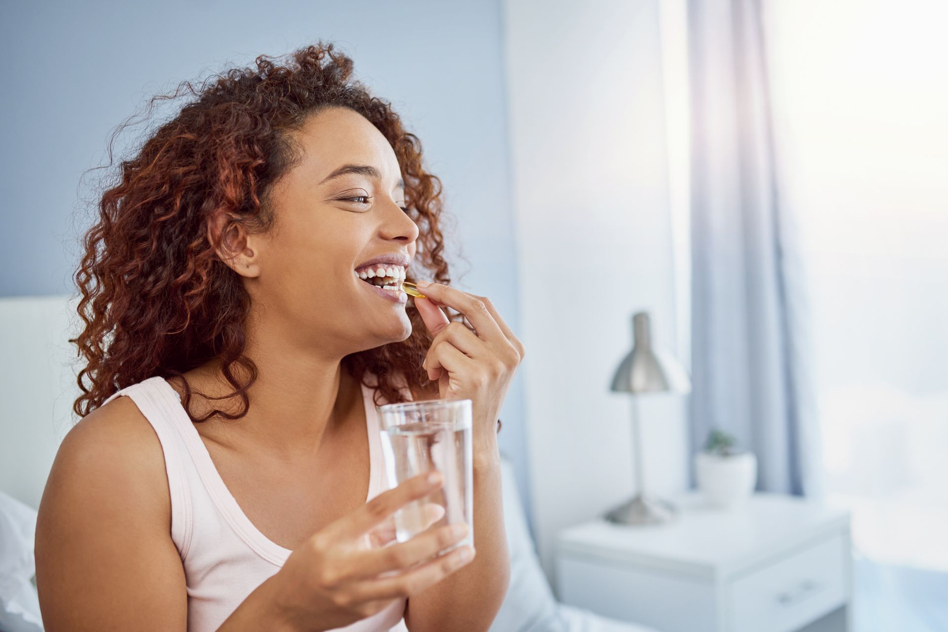 A person is holding three pills in their hand.