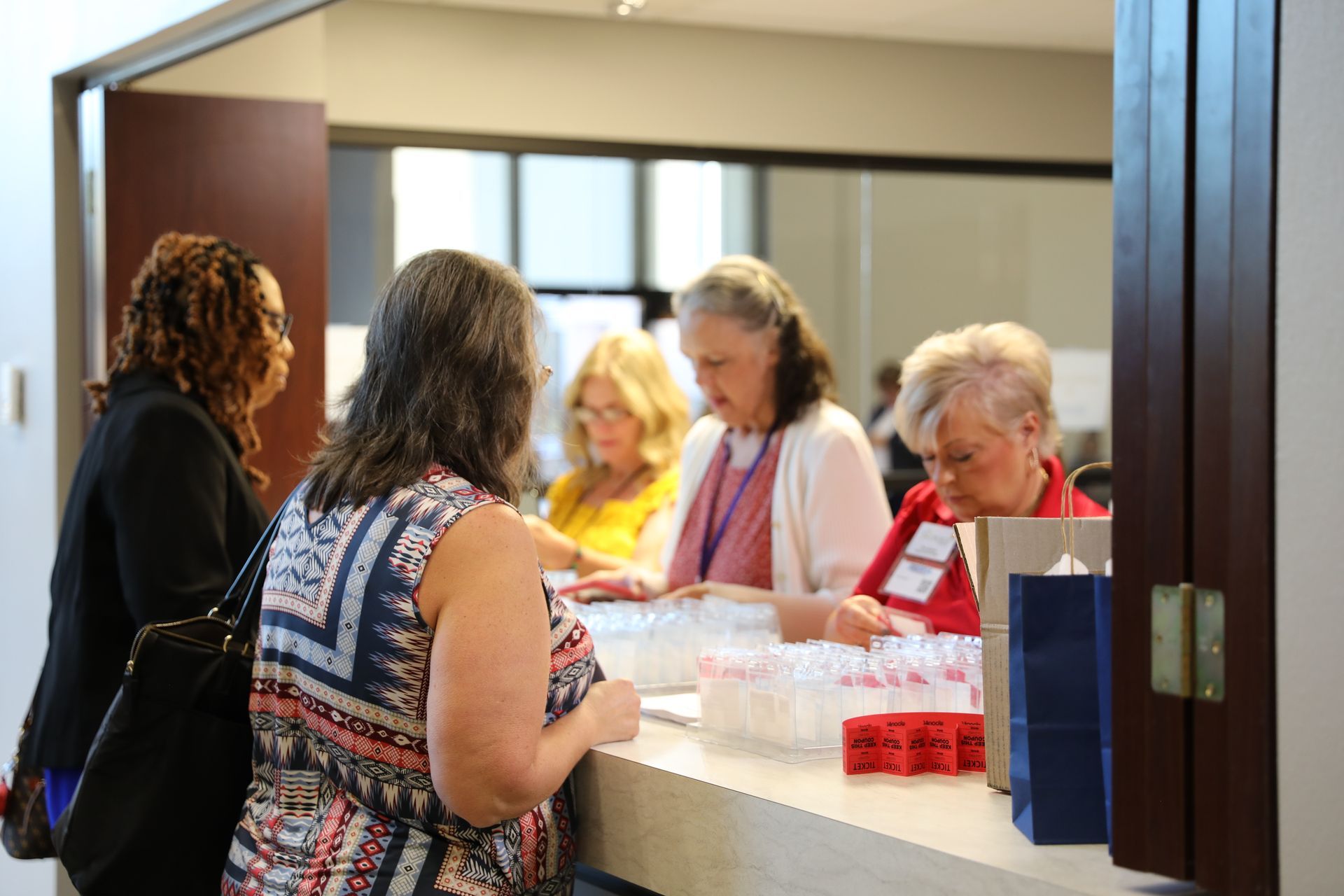 A group of women are standing at a counter in a room.