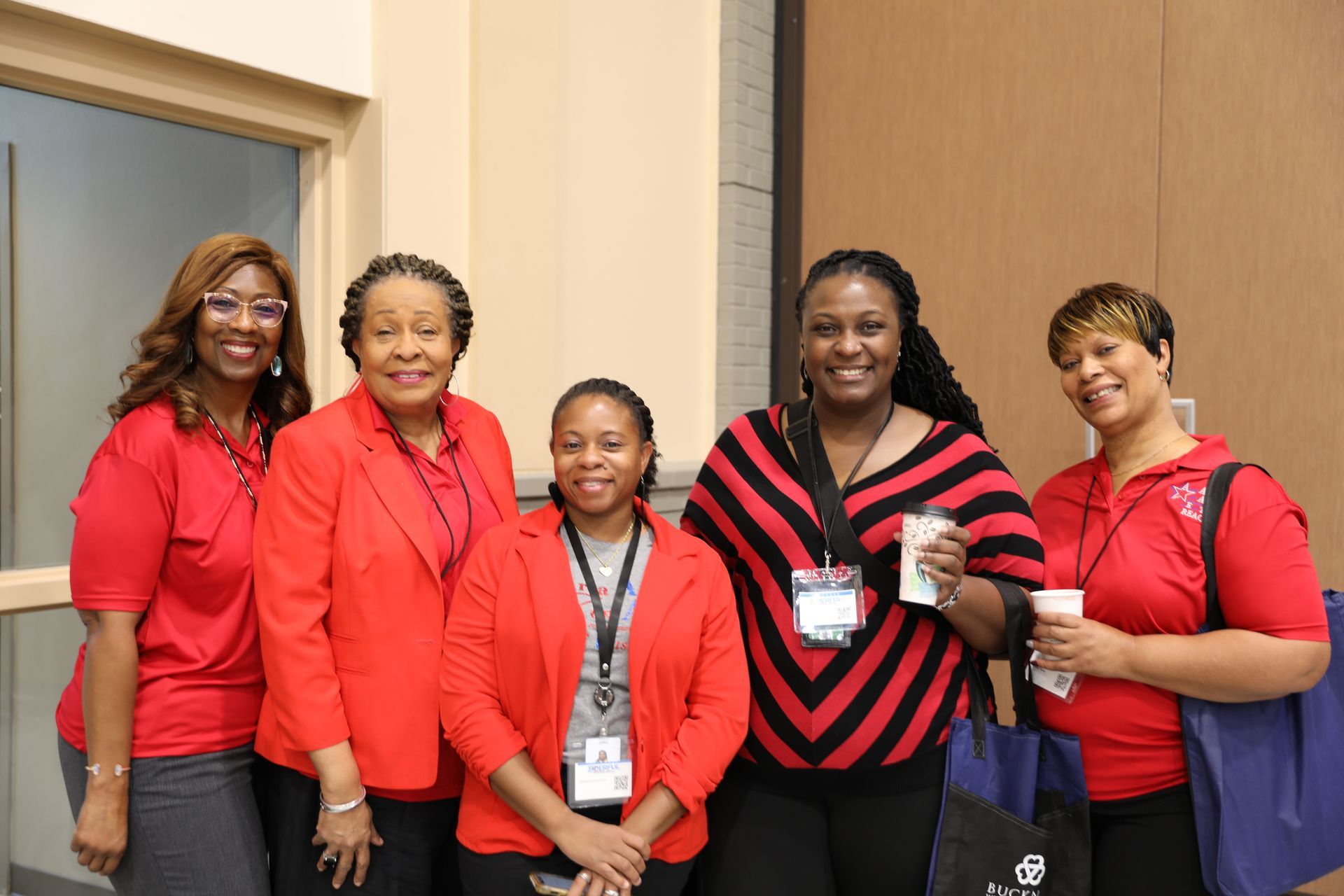 A group of women in red shirts are posing for a picture.