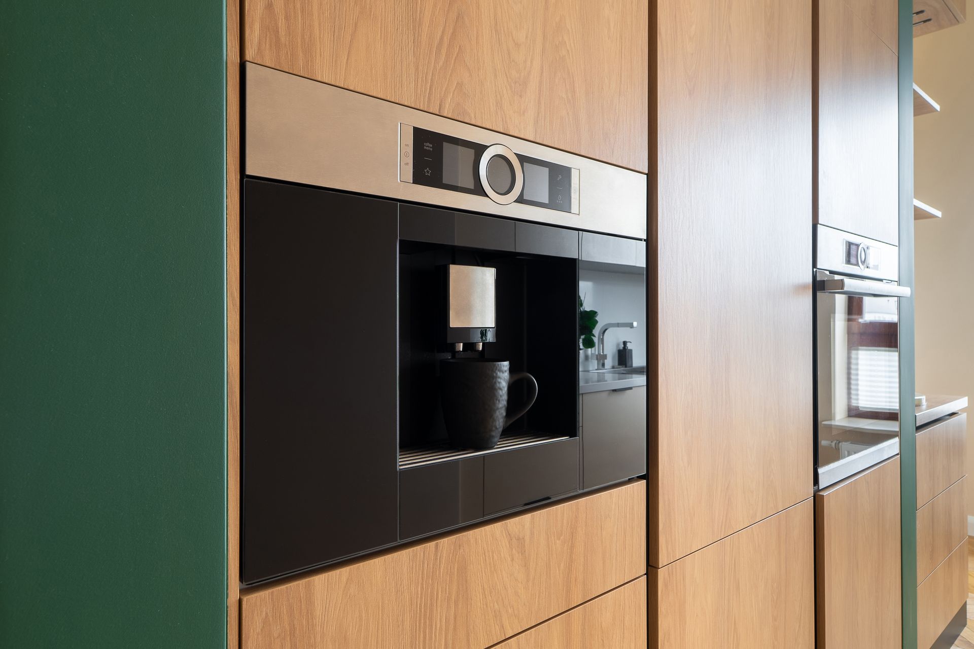 A coffee maker is built into the wall of a kitchen.