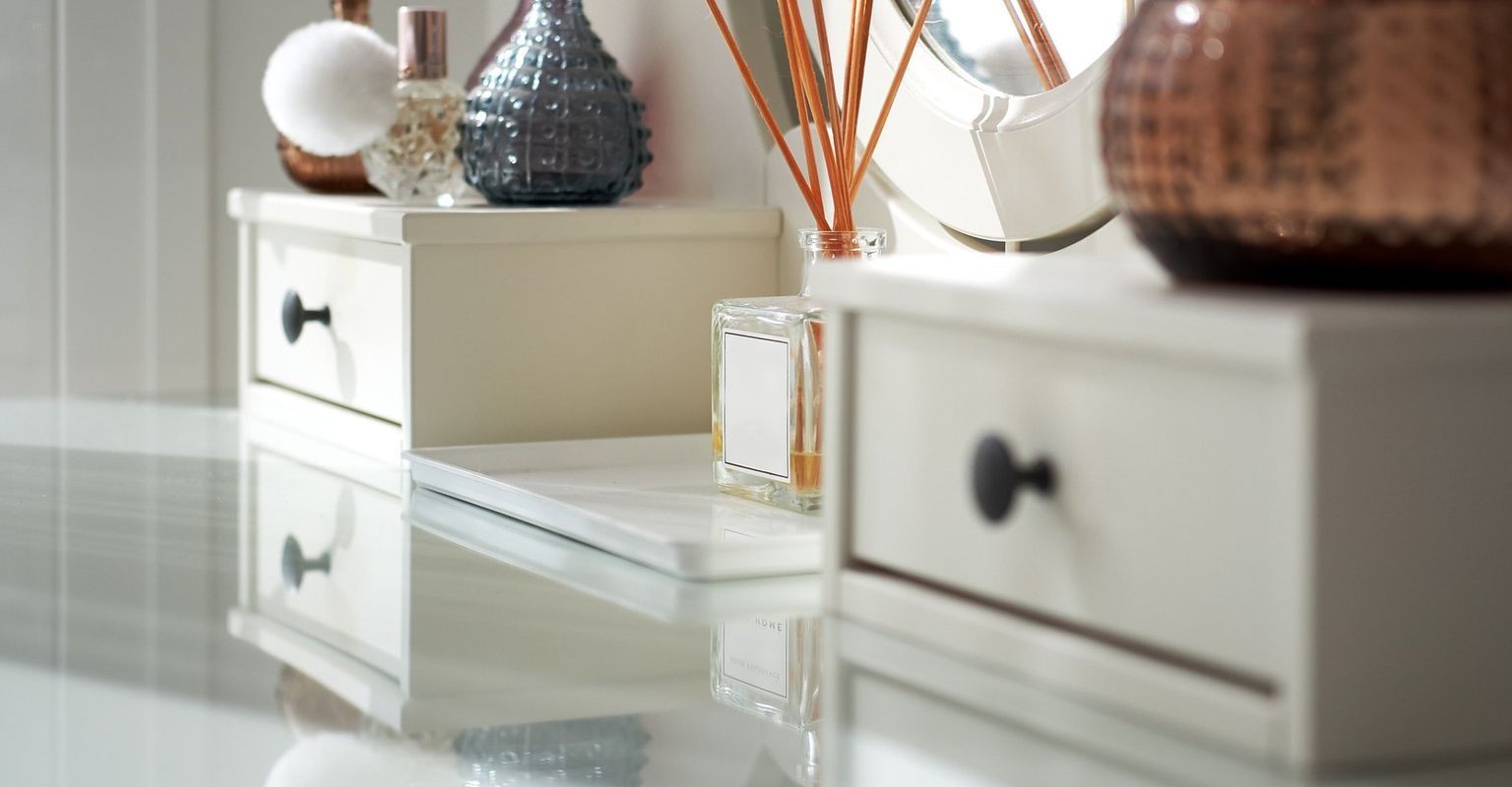 A bathroom with two white drawers and a mirror.