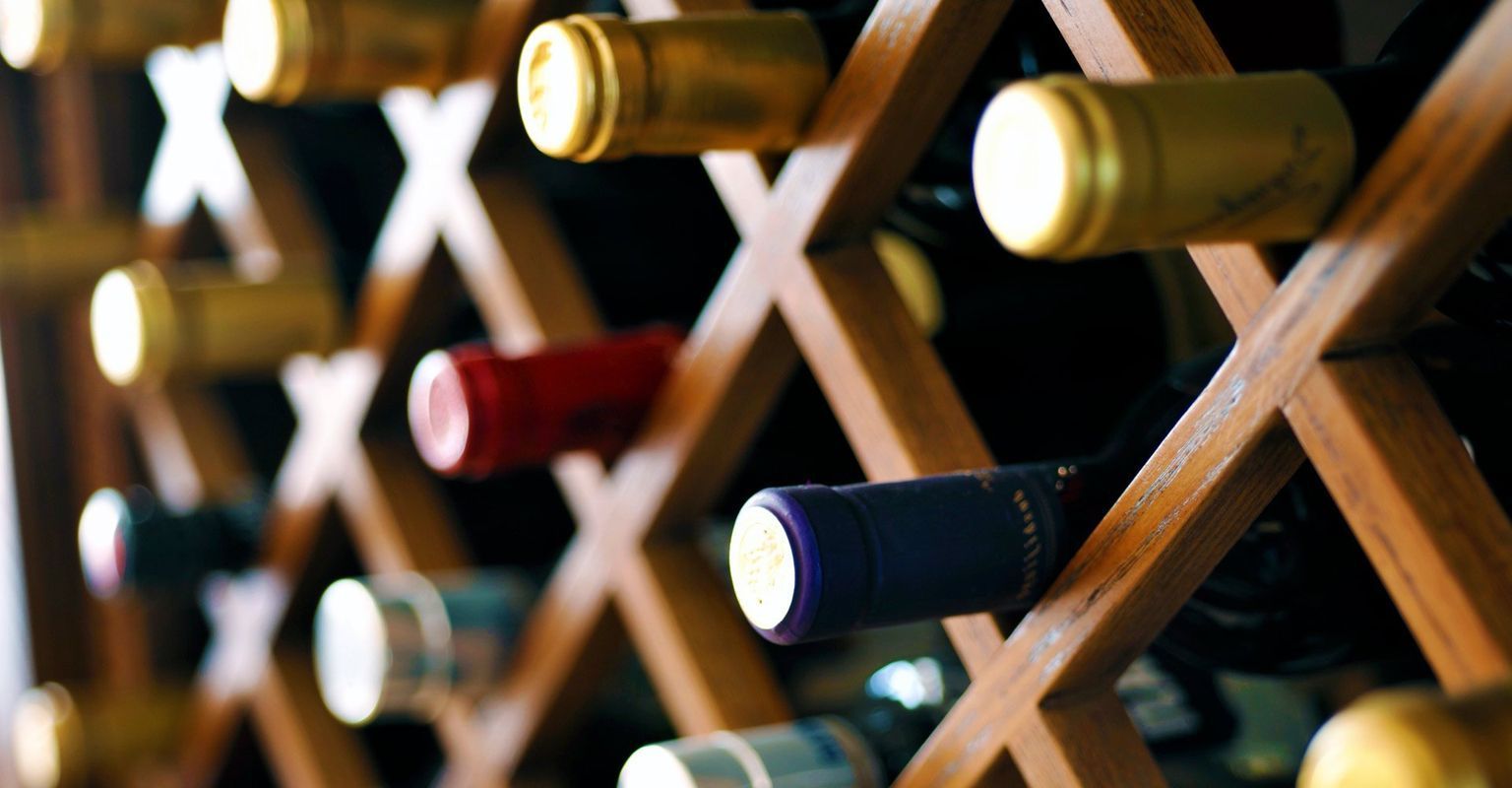 A wooden wine rack filled with bottles of wine.