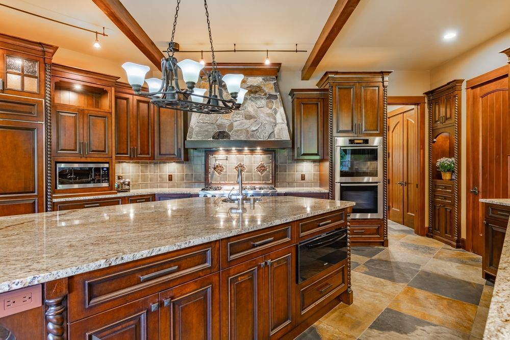 Woman in straw hat smiles, holding wine glass near a lake.