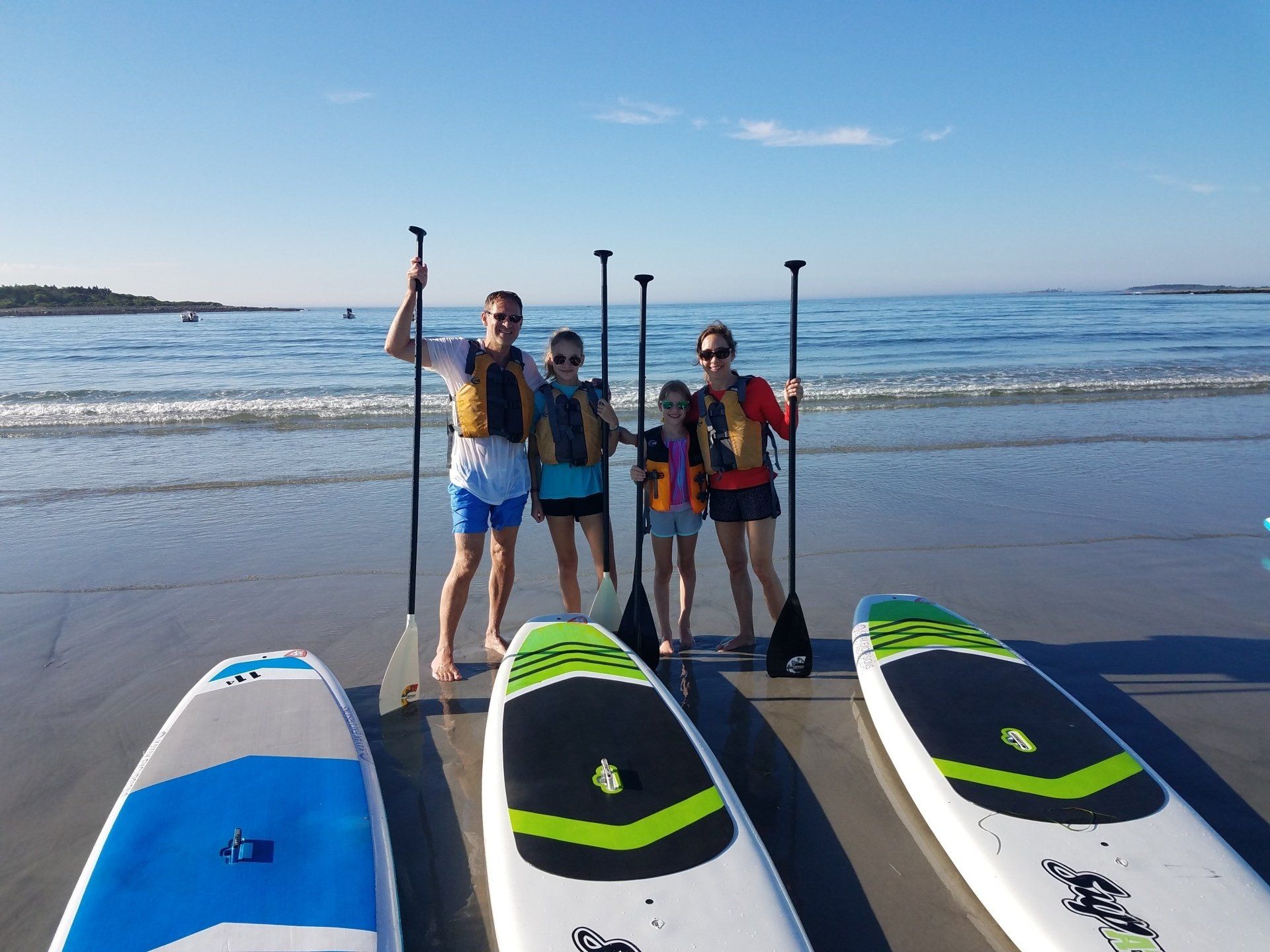 Family on the shore while holding the paddle
