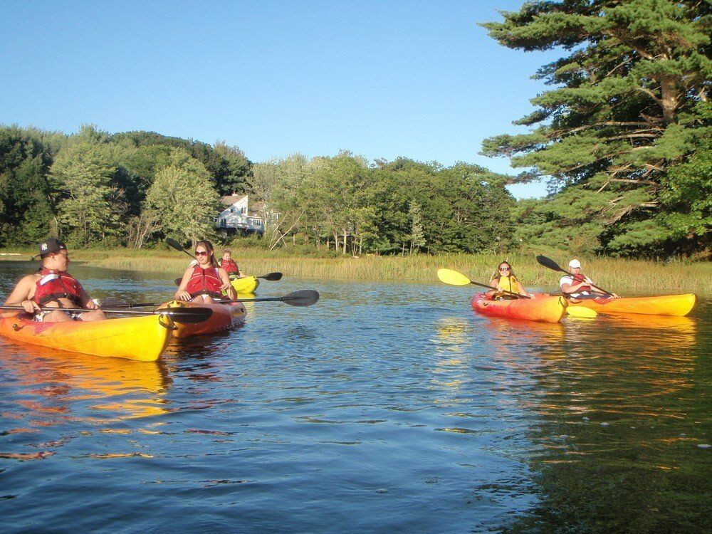 Group of people on red and orange kayaks