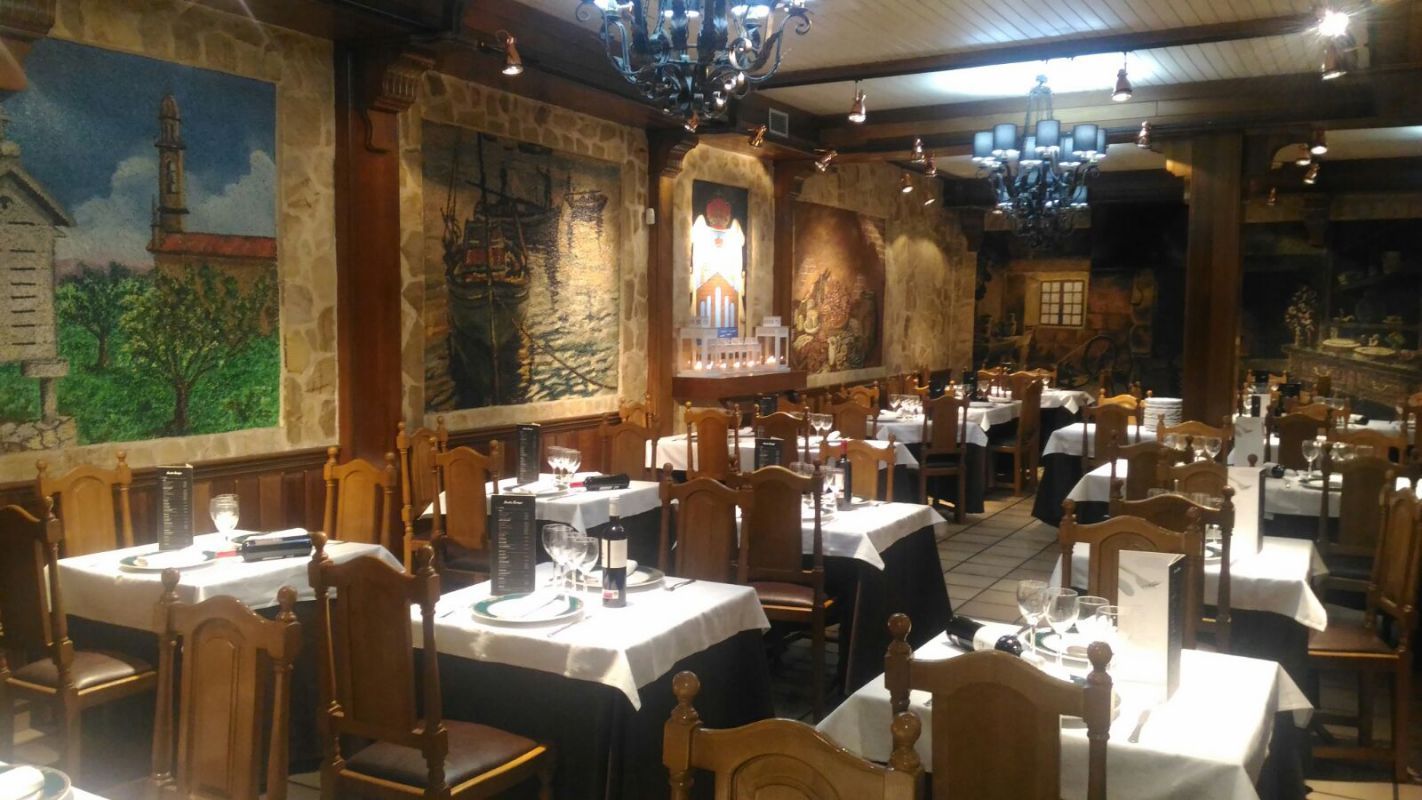 Un restaurante con mesas y sillas y un cuadro en la pared.