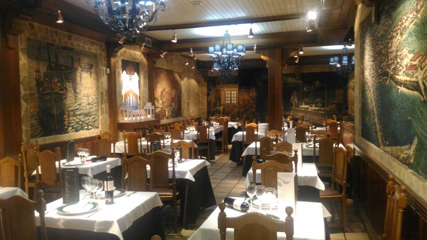 Un gran comedor con mesas y sillas y una lámpara de araña.