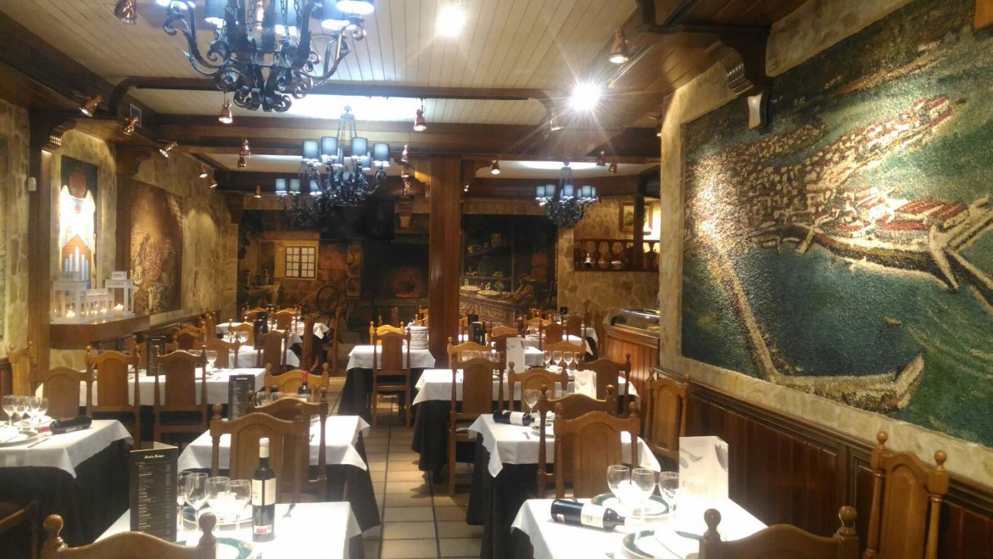 Un restaurante con mesas y sillas y un gran cuadro en la pared.