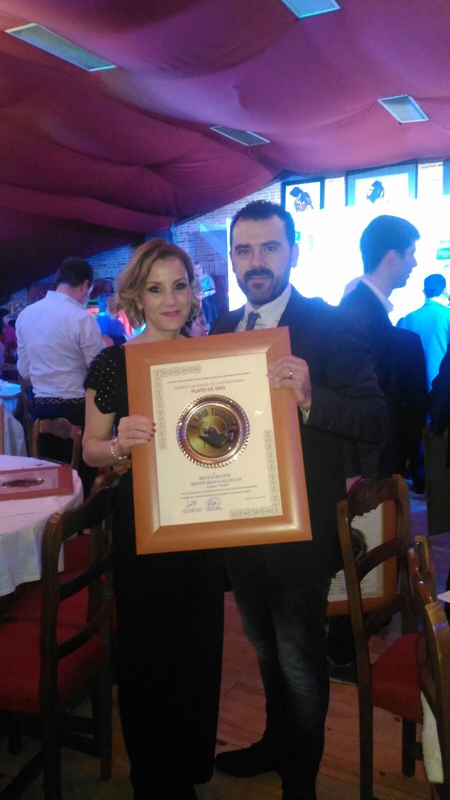 Un hombre y una mujer sostienen un certificado enmarcado.