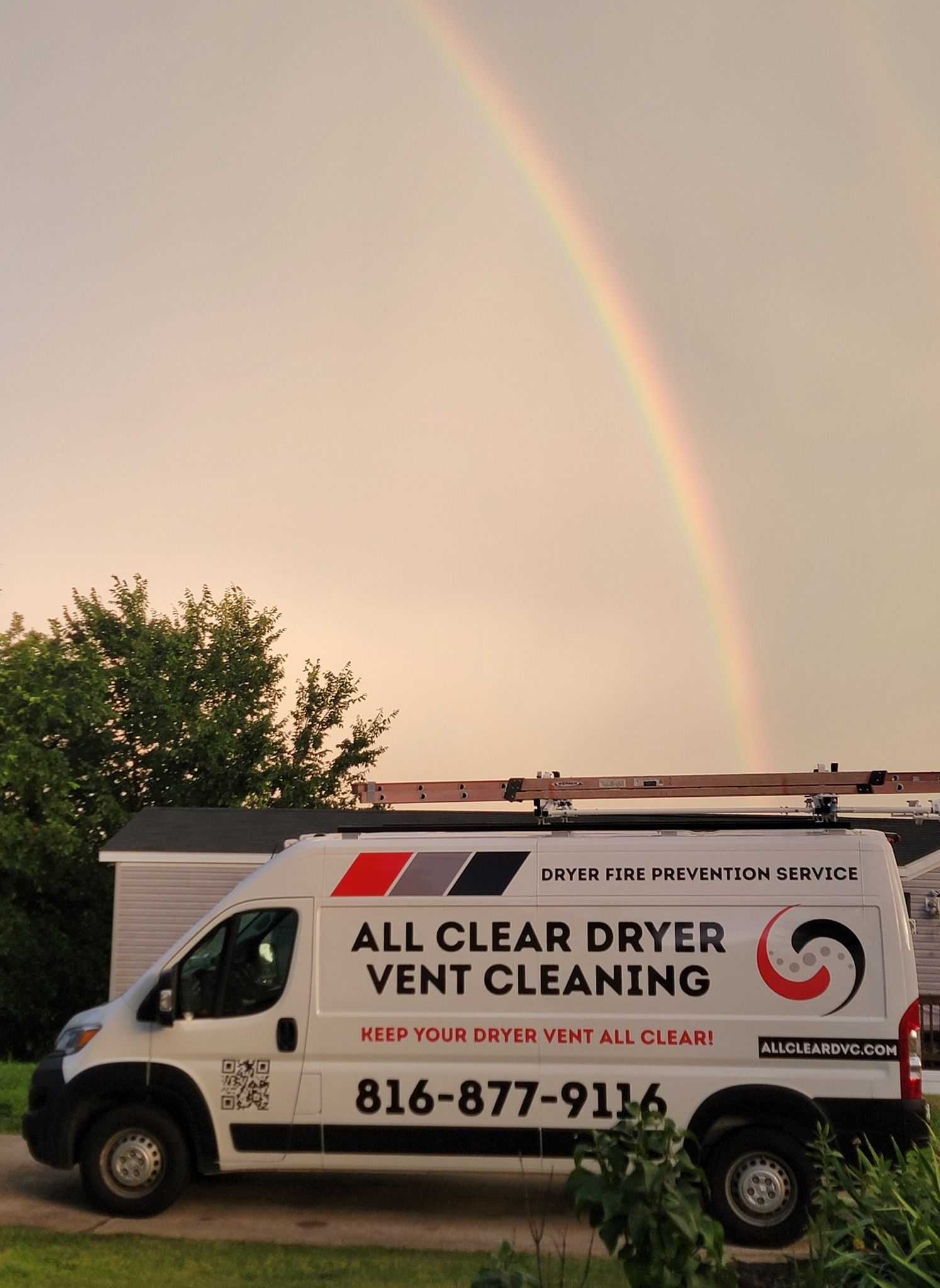 White service van for All Clear Dryer Vent Cleaning parked under a rainbow at sunset.