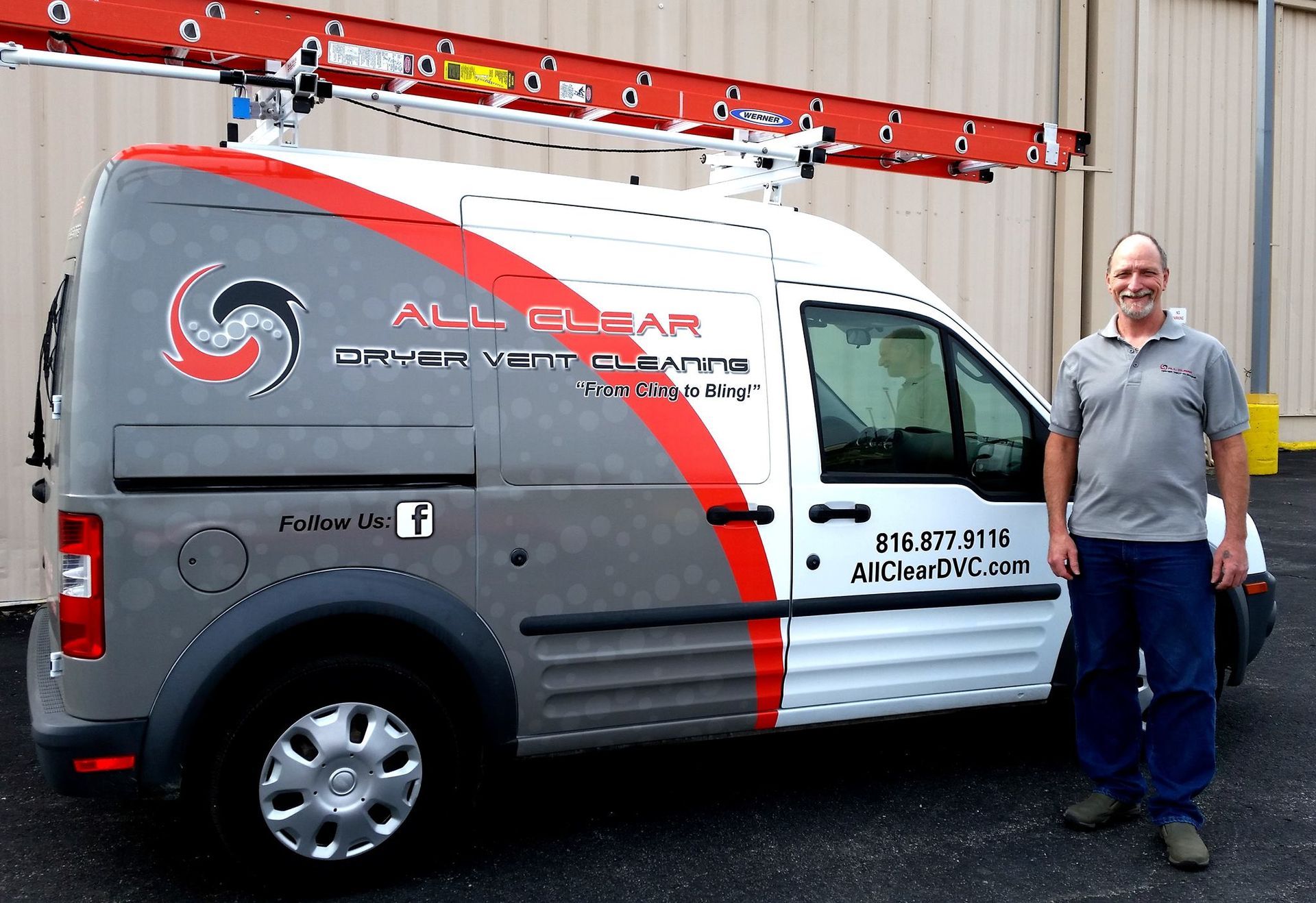 Man standing beside a white and gray service van with red graphics parked outside a building.