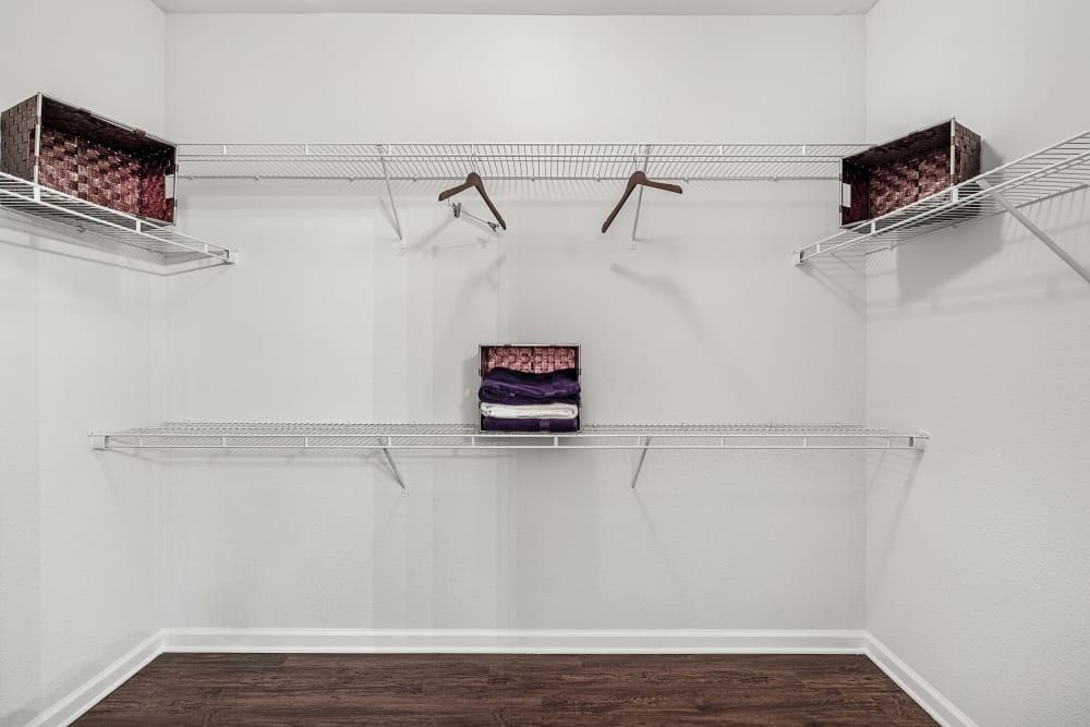 a walk-in closet with lots of shelves and clothes hanging on the wall at Marquis at Canyon Ridge in Austin, TX.