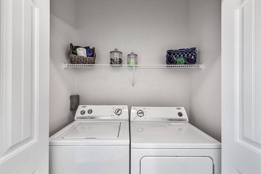 a laundry room with a washer and dryer in it at Marquis at Canyon Ridge in Austin, TX.