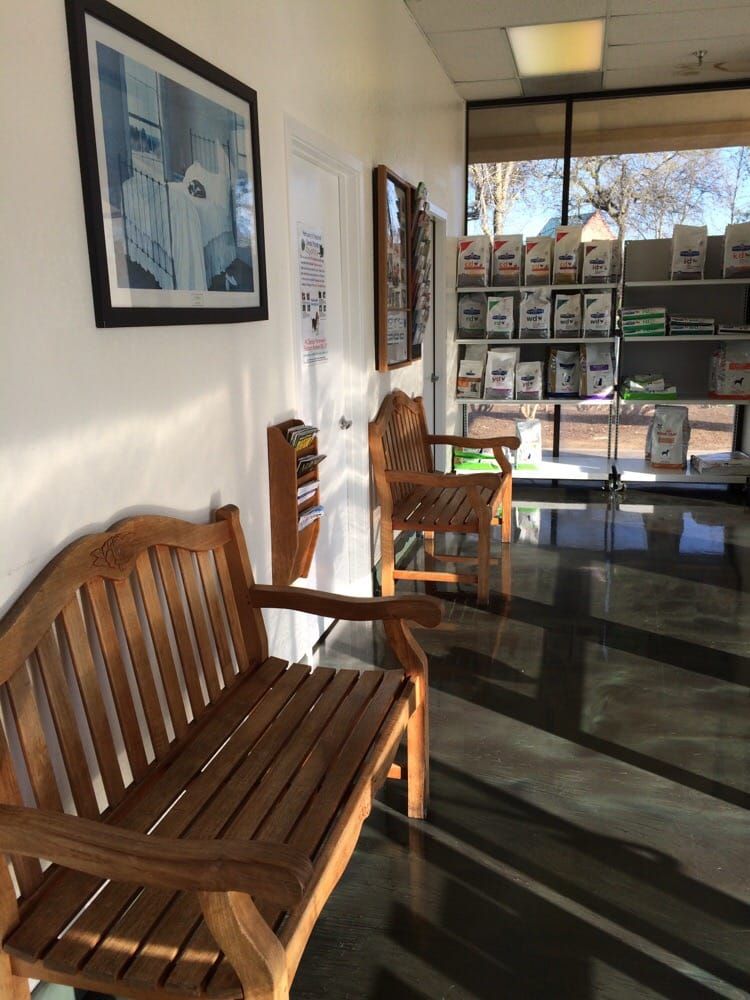 A waiting room with a wooden bench and chairs